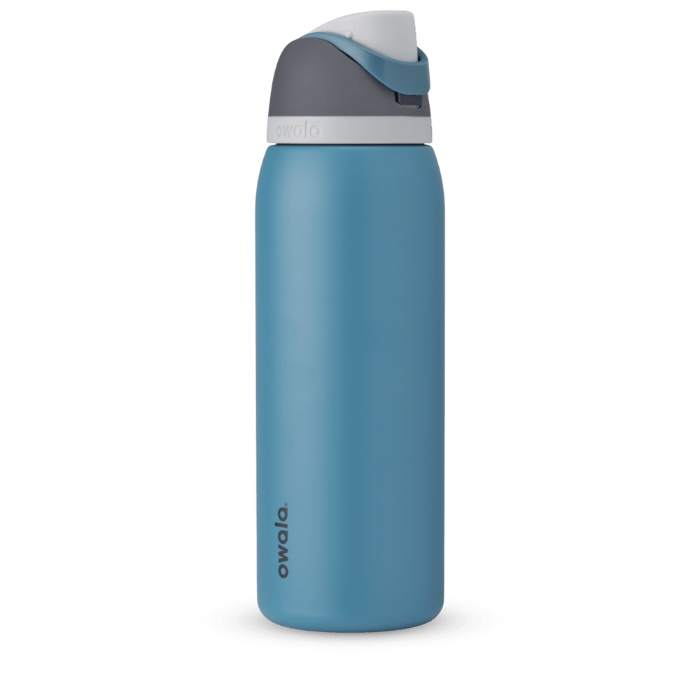 FreeSip 40oz in Blue Oasis, denim blue body with matching blue carry loop, dark gray flip cap, and white accent band